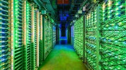 The blinking lights of racks of Google servers glow in a darkened data hall in St. Ghislain, Belgium. (Image: Google)