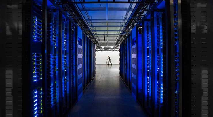 Rows of blue-lit server cabinets inside one of Facebook&rsquo;s data centers in Altoona, Iowa. (Photo: Facebook)