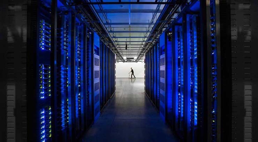 Rows of blue-lit server cabinets inside one of Facebook&rsquo;s data centers in Altoona, Iowa. (Photo: Facebook)