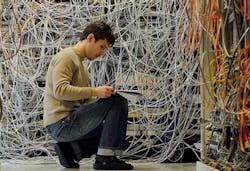Technician in front of a manual patch panel. (Photo: Telescent) Technician in front of a manual patch panel. (Photo: Telescent)