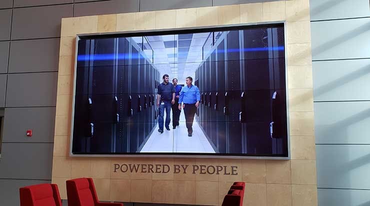 Data centers are powered by people. A video screen in the lobby of the QTS Data Centers facility in Ashburn, Va. (Photo: Rich Miller)