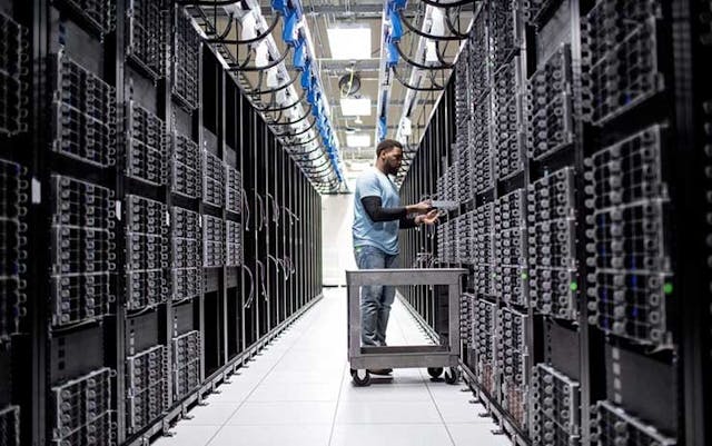 A technician works in rows of server racks in a Microsoft Azure cloud data center. (Image: Microsoft)