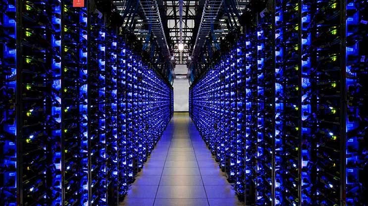 A blue-lit row of servers in a Google data center, (Photo: Google)