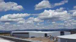 A cloud-filled sky above a Facebook cold storage data center, framed by the mountains of central Oregon. (Photo: Rich Miller)
