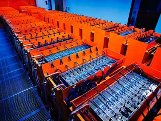 A look inside a DUG immersion-cooled data hall, showing the cooling enclosures filled with dieletric fluid and the piping where the cooling loop enters the enclosure. The Skybox deployment will use more than 700 of these tanks. (Photo: DownUnder GeoSolutions)