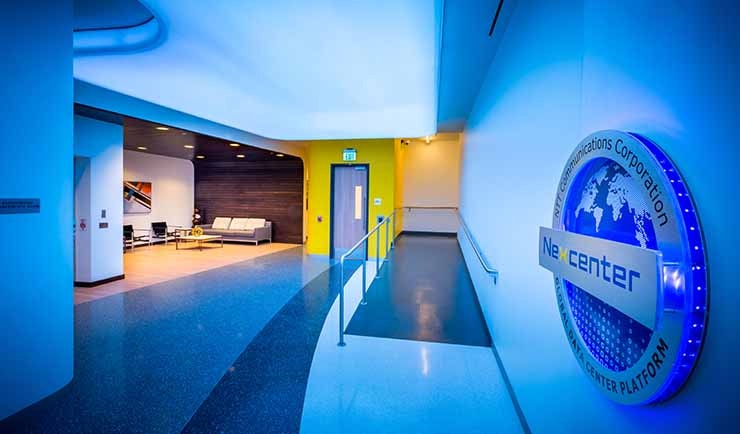 The lounge area at the entrance of the RagingWire VA2 data center in Ashburn, Virginia, featuring the logo for the NTT Nexcenter data center family. (Image: RagingWire)