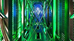 Inside the hot aisle of a Google data center, hundreds of fans funnel hot air from the server racks into a cooling unit to be recirculated. The green lights are the server status LEDs reflecting from the front of the servers. (Photo: Google)
