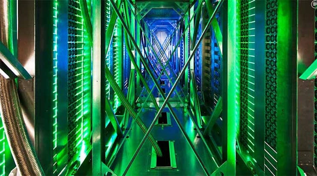 Inside the hot aisle of a Google data center, hundreds of fans funnel hot air from the server racks into a cooling unit to be recirculated. The green lights are the server status LEDs reflecting from the front of the servers. (Photo: Google)