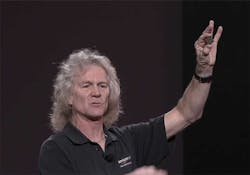 AWS Distinguished Engineer James Hamilton holds up a custom ASIC created by Amazon to power its networking gear. (Screen shot via Amazon video) AWS Distinguished Engineer James Hamilton holds up a custom ASIC created by Amazon to power its networking gear. (Screen shot via Amazon video)