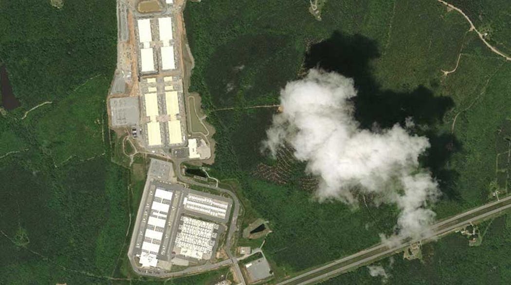 A satellite view of the massive Microsoft cloud campus in Boydton, Virginia, with a cloud casting a shadow over the landscape.