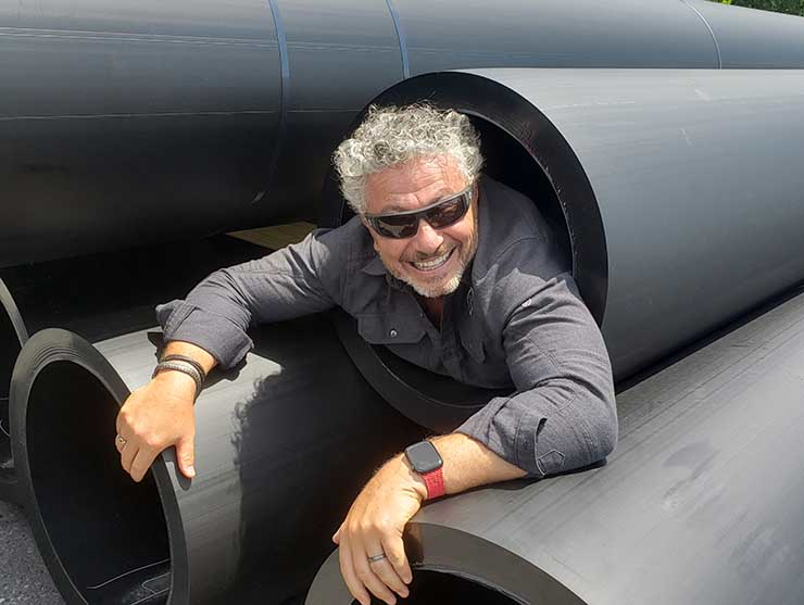 Quantum Loophole CEO Josh Snowhorn testing one of the giant conduits that will house fiber for the QLoop, the company's fiber ring connecting the new campus to Data Center Alley in Northern Virginia.