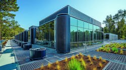 An AI-generated rendering of a 'renewable energy powered data center surrounded by green landscaping in a sustainable facility.' An AI-generated rendering of a 'renewable energy powered data center surrounded by green landscaping in a sustainable facility.'
