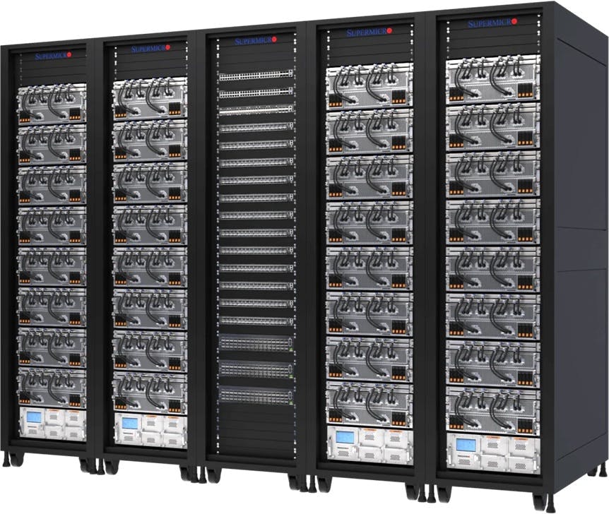 Supermicro&rsquo;s liquid-cooled AI cluster at xAI&rsquo;s Colossus facility, showing 32 NVIDIA HGX H100/H200 8-GPU, 4U systems&mdash;256 GPUs total&mdash;deployed across five high-density racks.
